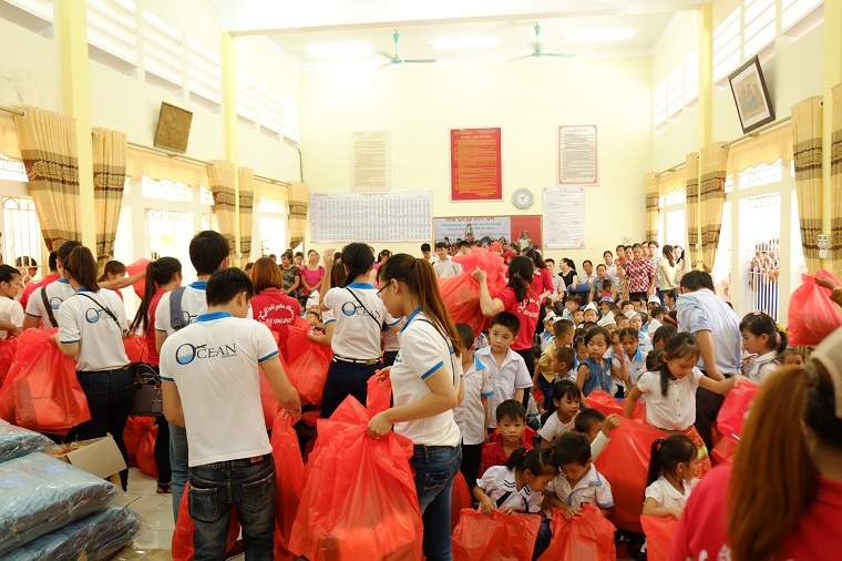 Các thành viên của đoàn từ thiện trao tặng 230 chiếc áo ấm đến với các em học sinh tại trường